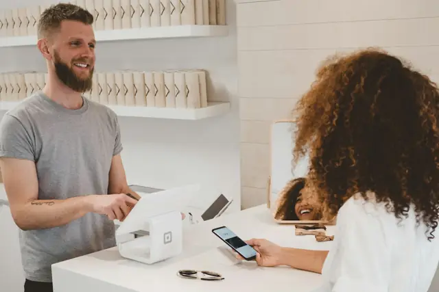 A cafe owner chatting with a customer across the counter