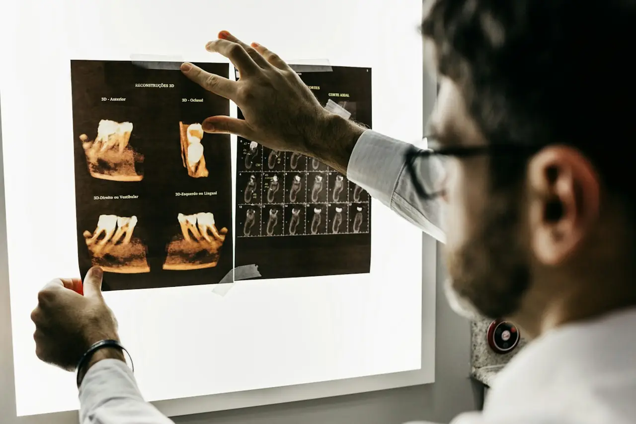 A dentist reviewing X-rays on a lightbox in a clinic