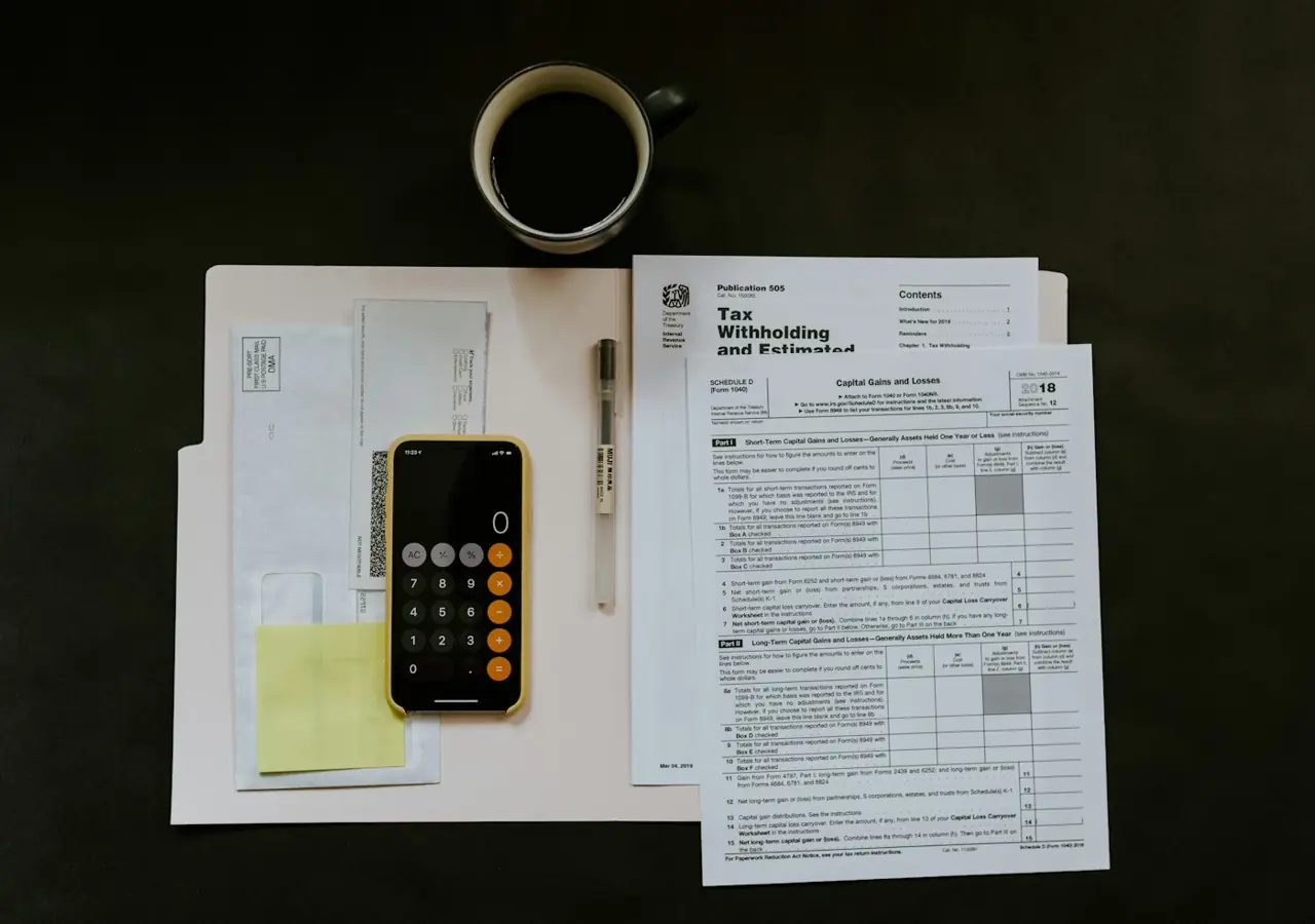 Receipts, a calculator and printed statements spread on a dark desk