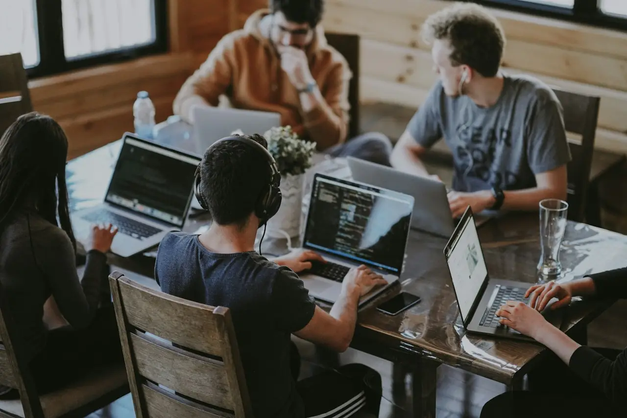 A small team working on laptops around a shared table